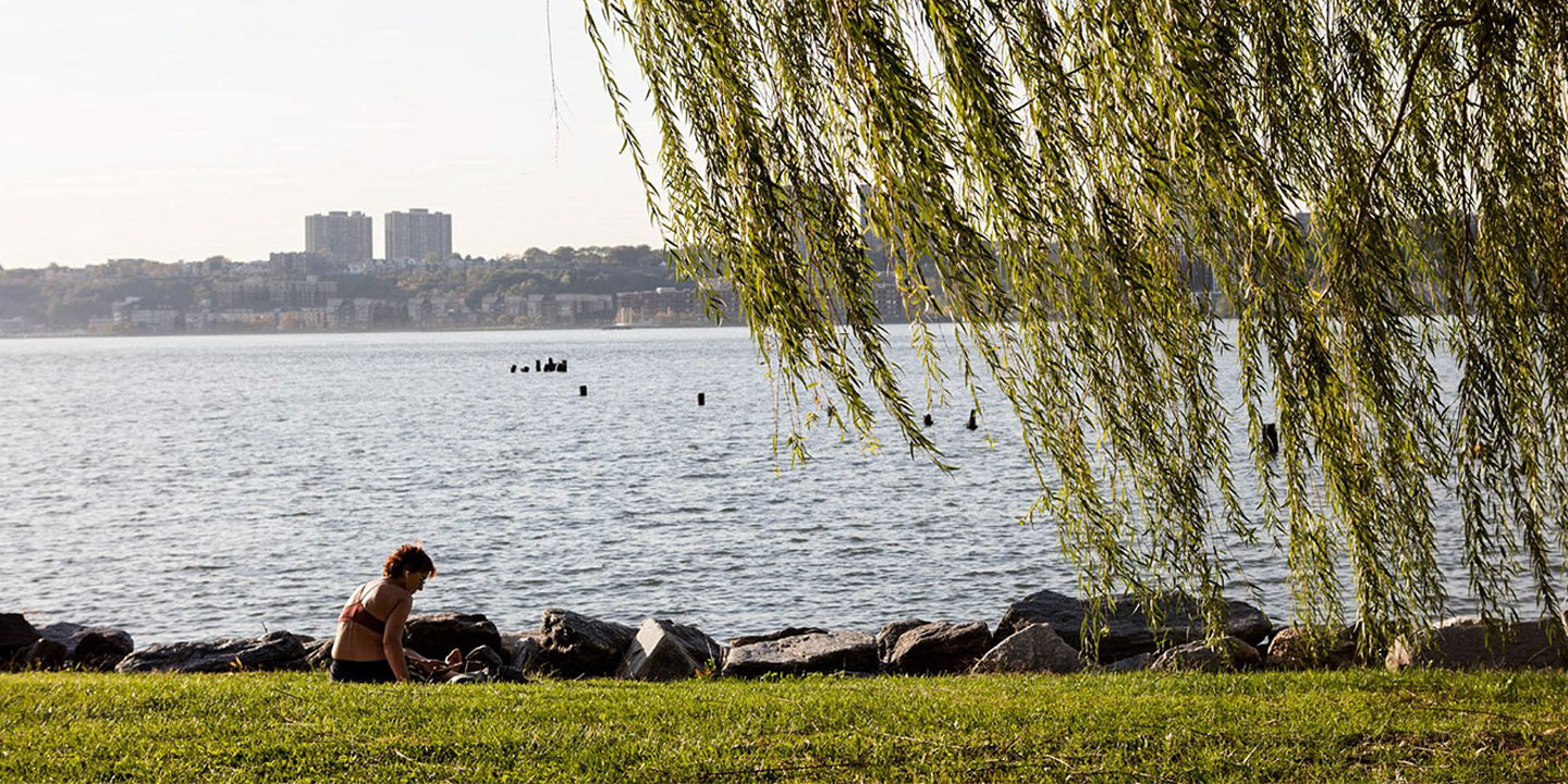 woman relaxing in the grass by the riverside hero