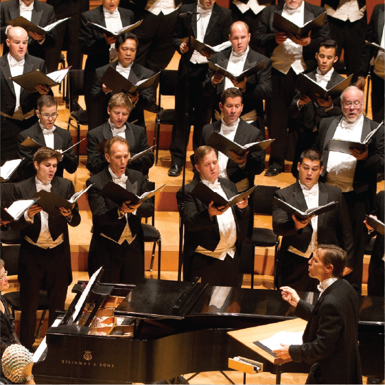 A choir performing with intensity, accompanied by a grand piano, under the guidance of an impassioned conductor.