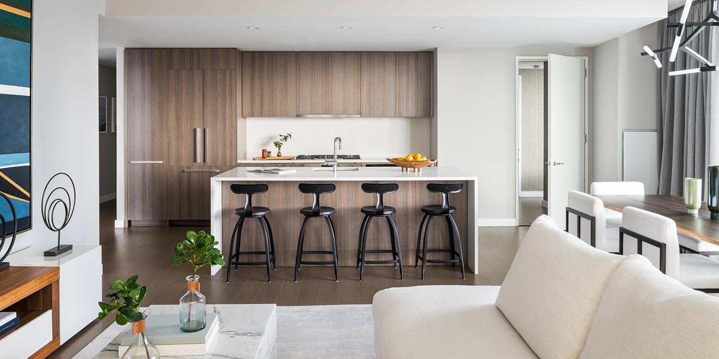 Modern kitchen with a central island featuring bar stools and a neat, minimalist design.
