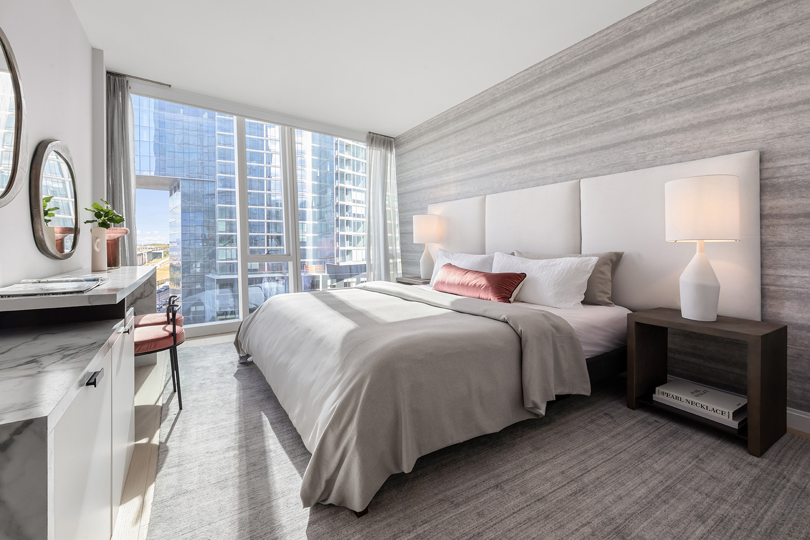 Modern and bright hotel room with a large bed, city view, and elegant furnishings.