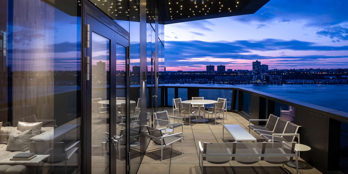 Twilight serenity: a modern rooftop terrace overlooking a tranquil city skyline as day transitions to night.