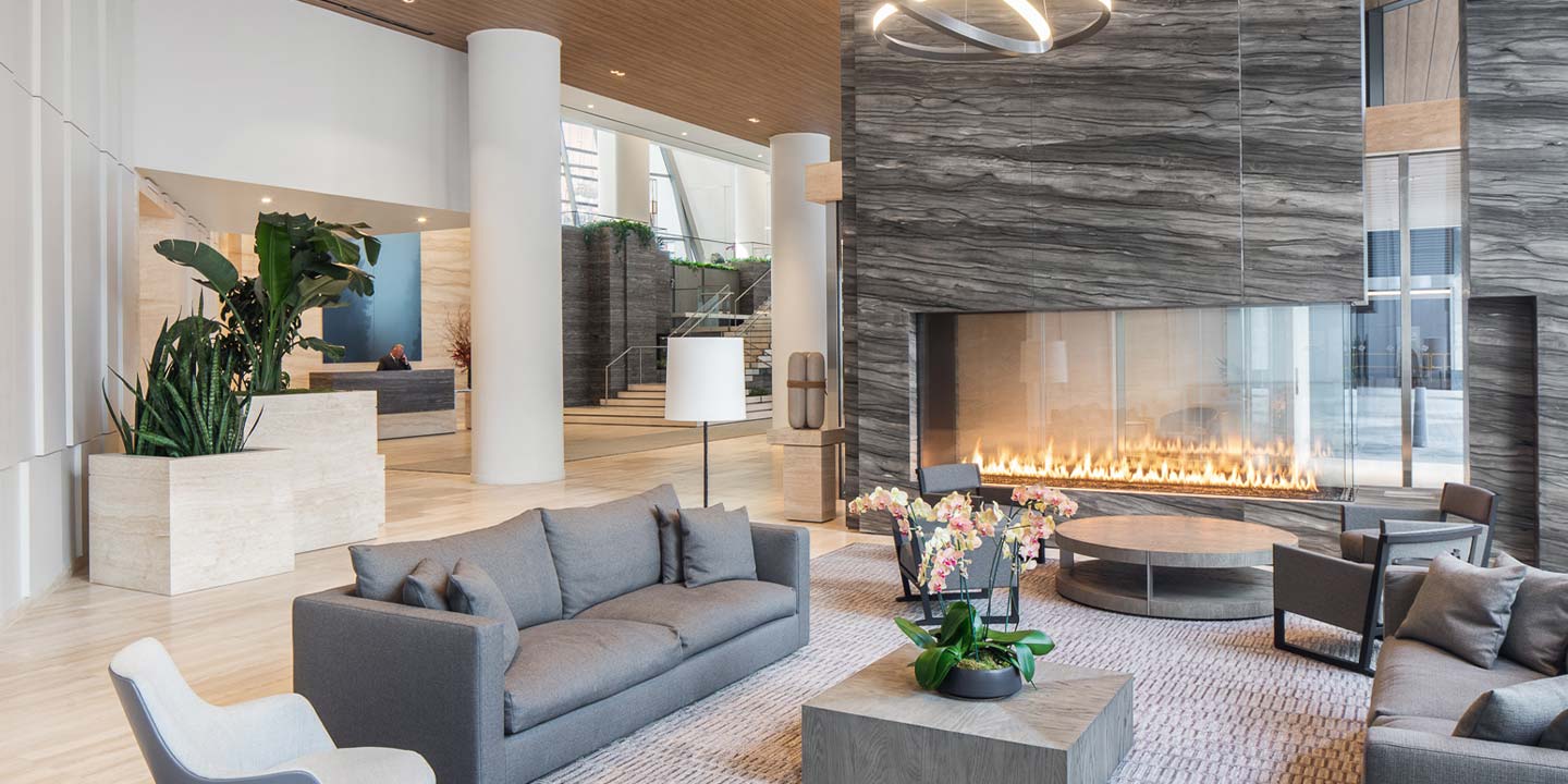 Modern hotel lobby with sleek design featuring a comfortable seating area, a cozy fireplace, and a welcoming reception desk.