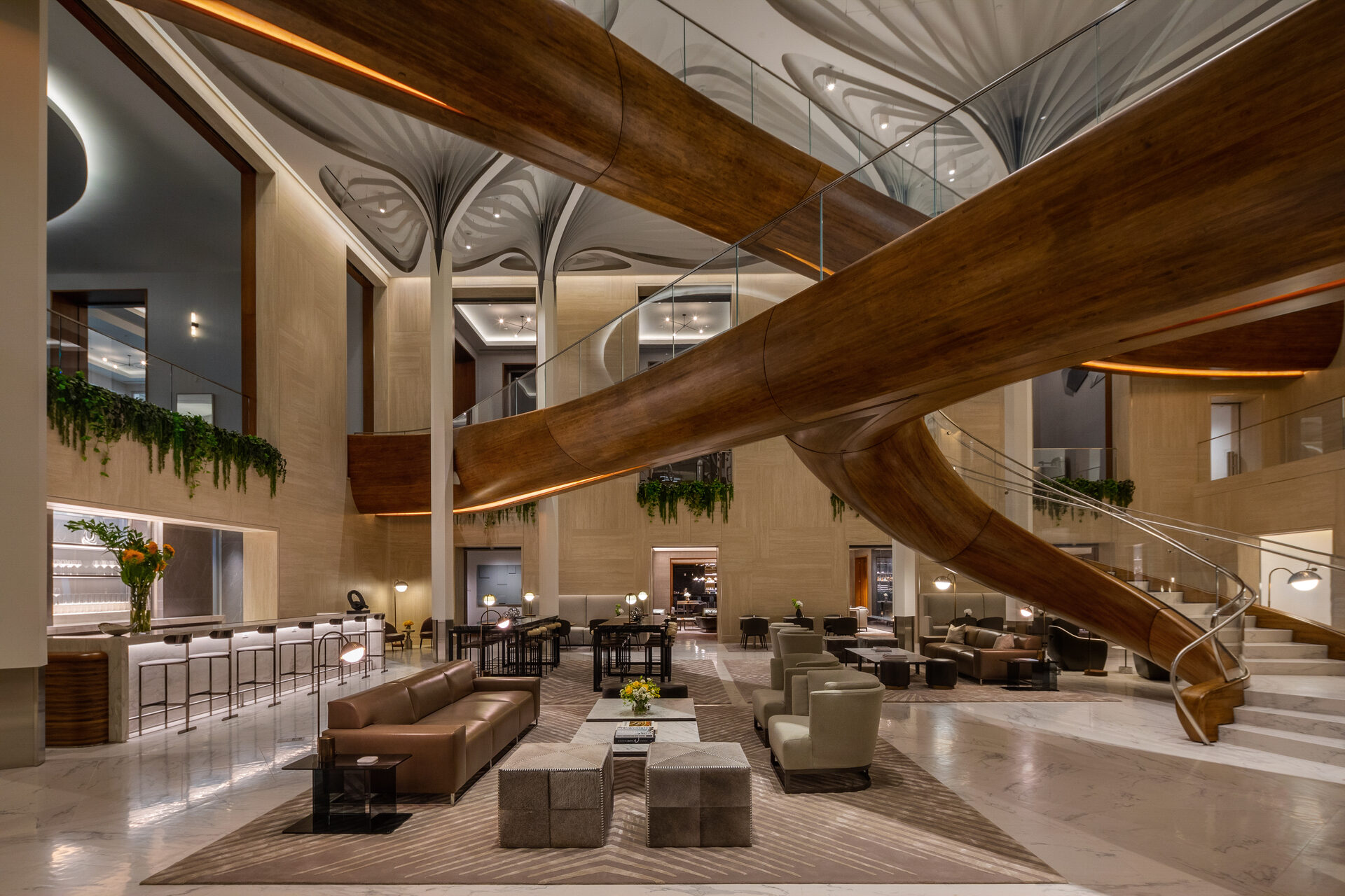 Modern hotel lobby with luxurious wooden design elements and elegant spiral staircase.