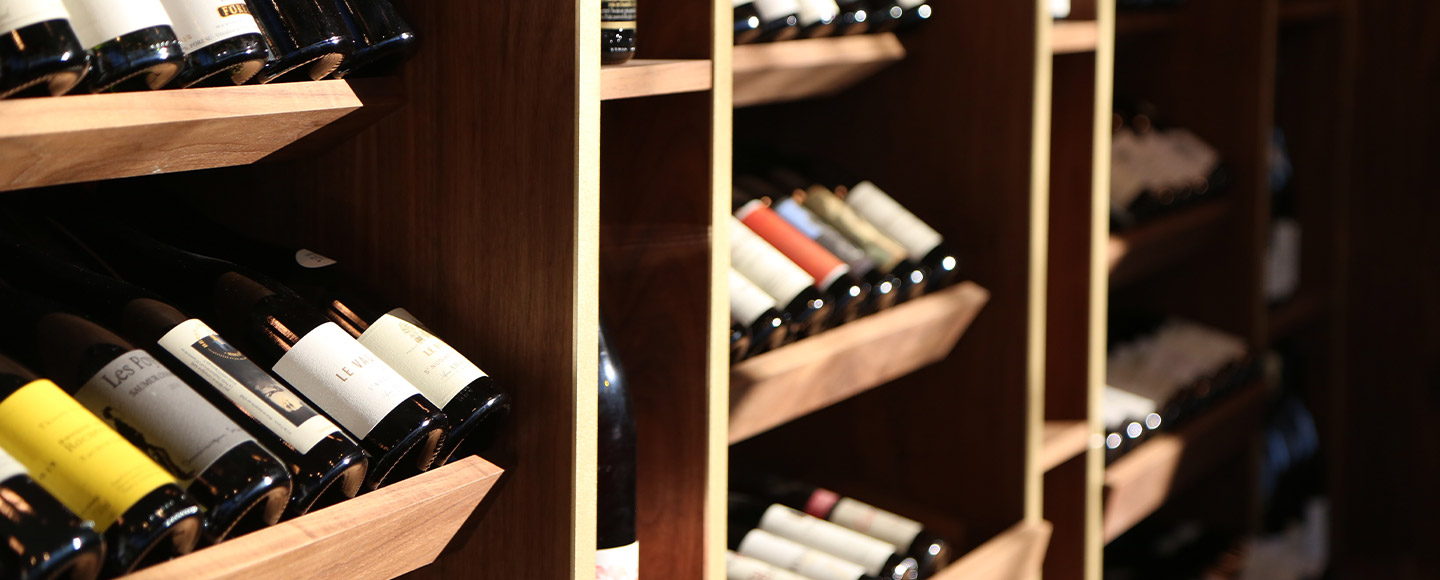 Rows of wine bottles stored horizontally on wooden shelves, showcasing a sophisticated wine collection.